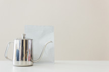 silver tea pot and tea bag 