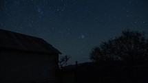 Timelapse of stars over an old barn on a peaceful night