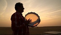 man with a tambourine in the desert 
