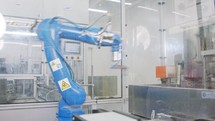 Robotic line at a manufacturing facility. Robot placing metal parts