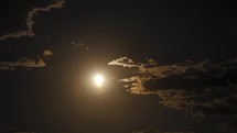 Timelapse of the full moon rising through clouds