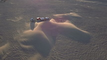 Aerial orbit of RV campers near sand dunes in the desert