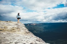 woman walking on the edge of a cliff 