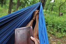 reading a Bible in a hammock 