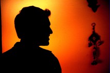 silhouette of a man with glowing orange and yellow background 