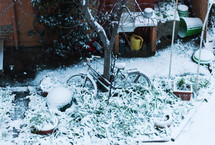 Bicycle covered with snow in a garden.