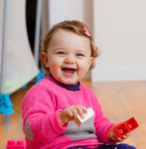 happy toddler girl playing with blocks 