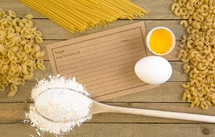 recipe card, wooden spoon, flour, noodles, pasta, and cracked egg