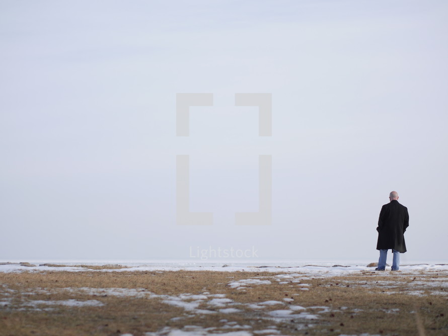 a man walking across a field with snow 