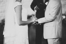 A bride and groom hold hands during the wedding ceremony.