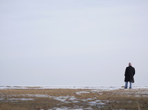 a man walking across a field with snow 