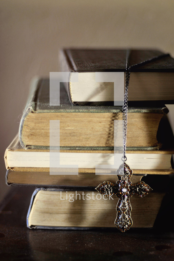 criss necklace on a stack of books 