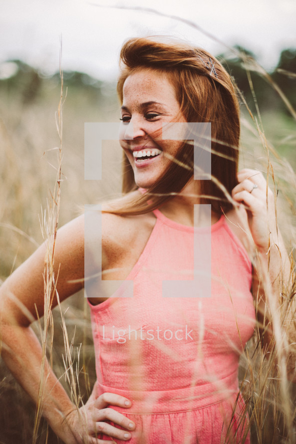 Smiling woman standing in a wheat field.