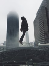 man leaping up in a city 