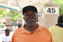 African American man in a orange shirt standing outdoors 
