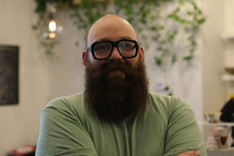 A bald man with a heavy beard and glasses.