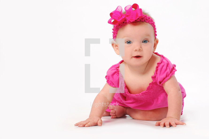infant girl in fuchsia crawling