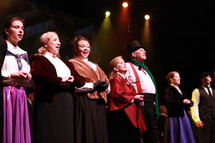 performers singing on stage - Christmas Carol