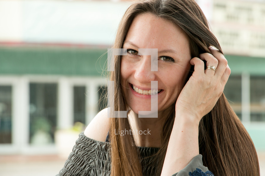 a woman tucking her hair behind her ear 