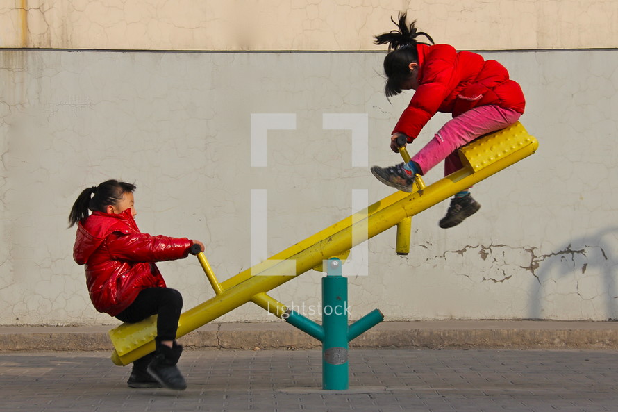 two little girls on a seesaw 