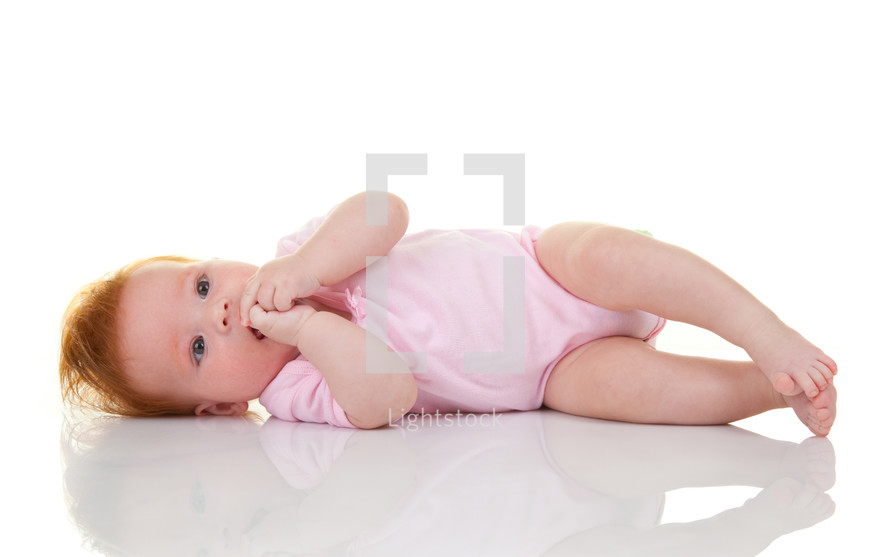 baby girl lying on white background