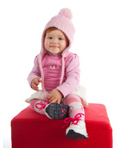 smiling baby with pink woolen hat on white background
