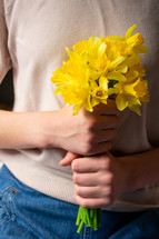 girl holding yellow daffodils 