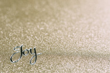 word joy on gold glittery background 
