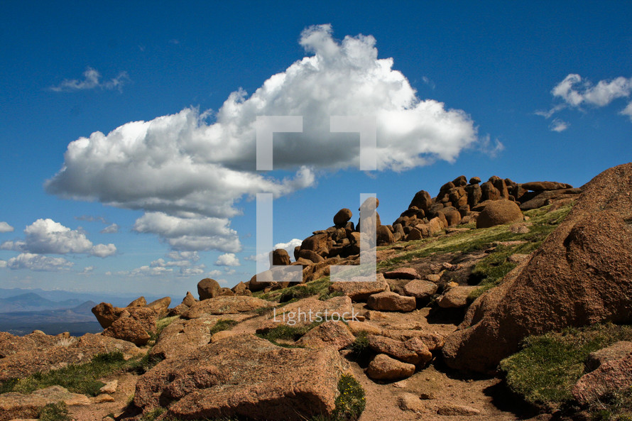 clouds in the sky over red rocks on a mountain 