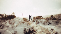 Photographer waving in snow dunes.