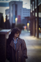 a woman in a trench coat in a city 