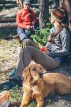 women campers sitting next to a dog 