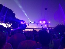 spotlights above a crowd at an outdoor concert 