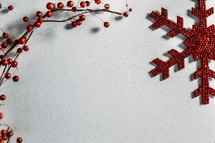 red berries and snowflake ornaments on white background 