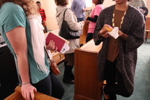 people eating donuts and talking before a worship service 