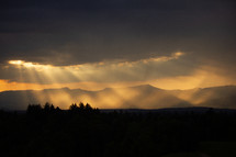 Eveningsun shining trough clouds on a mountain