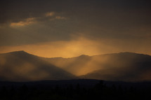 Eveningsun shining trough clouds on a mountain