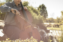 man playing a cello outdoors 