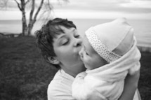 a brother kissing his baby sister 