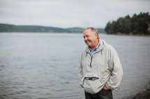 a man standing by a lake shore 