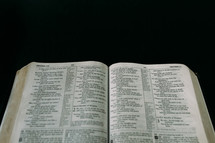 open Bible against a black background 