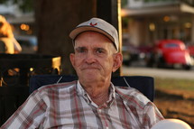 An older man sitting outside.