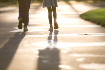 mother and daughter walking on a paved path 