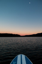 paddle board on a lake at sunset 