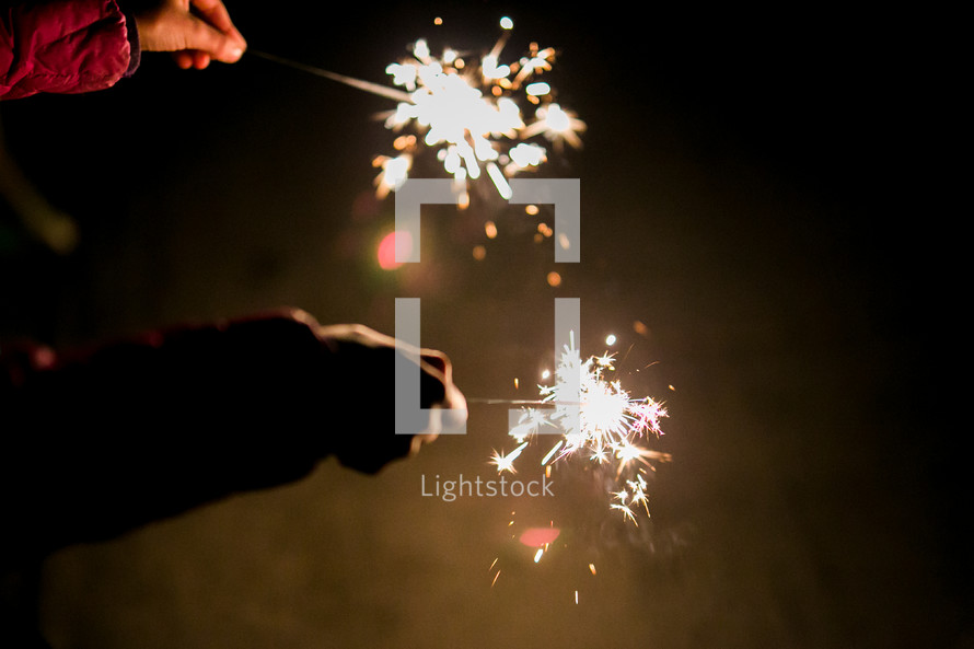 children holding sparklers at night 
