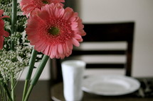 Bouquet of Gerber daisies on a set table.