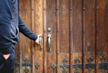 a man opening a wooden door 