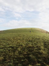 man standing on a green hill 