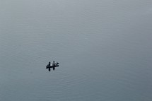 fishermen standing on a boat on a lake