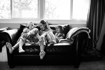sisters laughing on a couch 